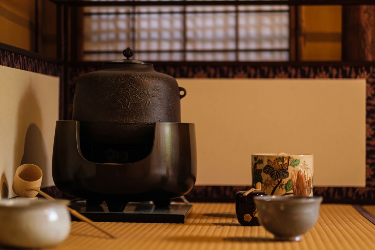 火窓に炭ではなく電熱器が入った風炉と、松の地紋の釜。敷板の右から畳へコードが伸びている