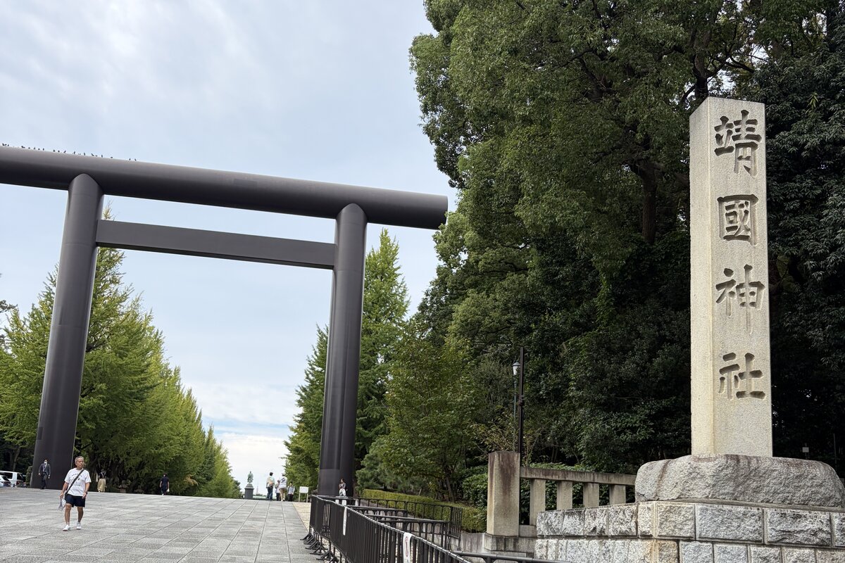 靖國神社の大鳥居と「靖國神社」の社号標。参道の銀杏並木はまだ緑